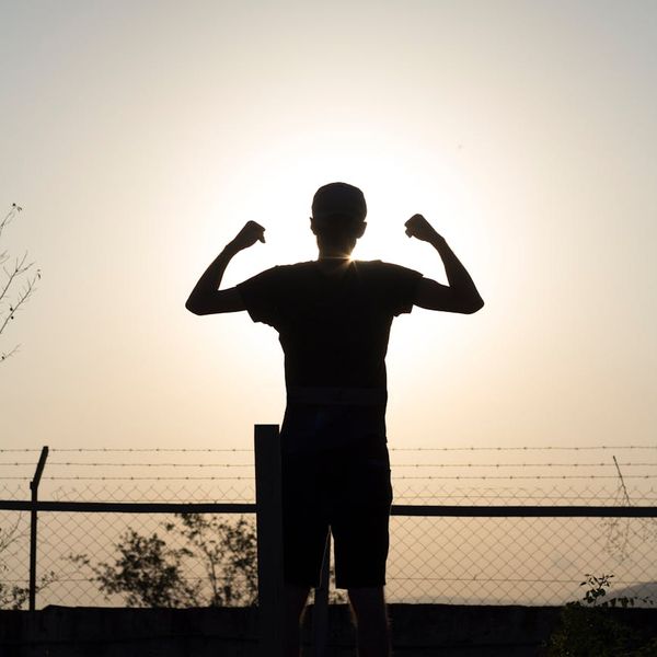 Silhouette of a person stretching during sunrise, symbolizing renewed energy.