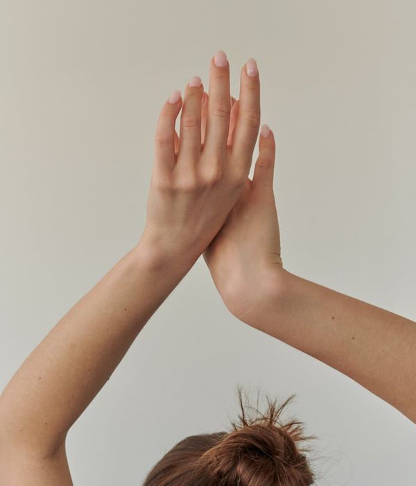 Woman in a calm, balanced pose against a dark, minimalist background.
